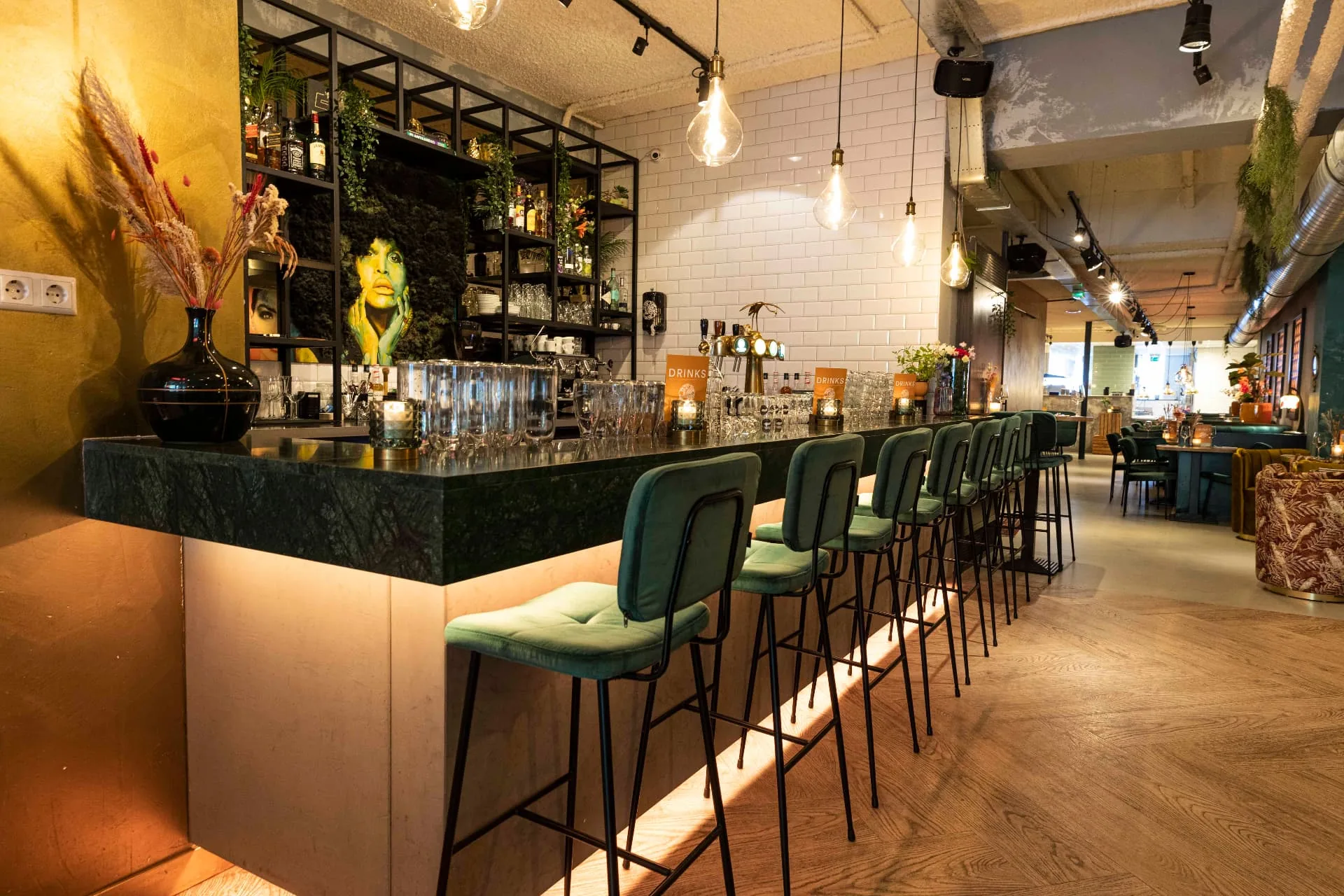 Bar van WAKU WAKU in Utrecht met groene krukken, witte tegels en warme verlichting