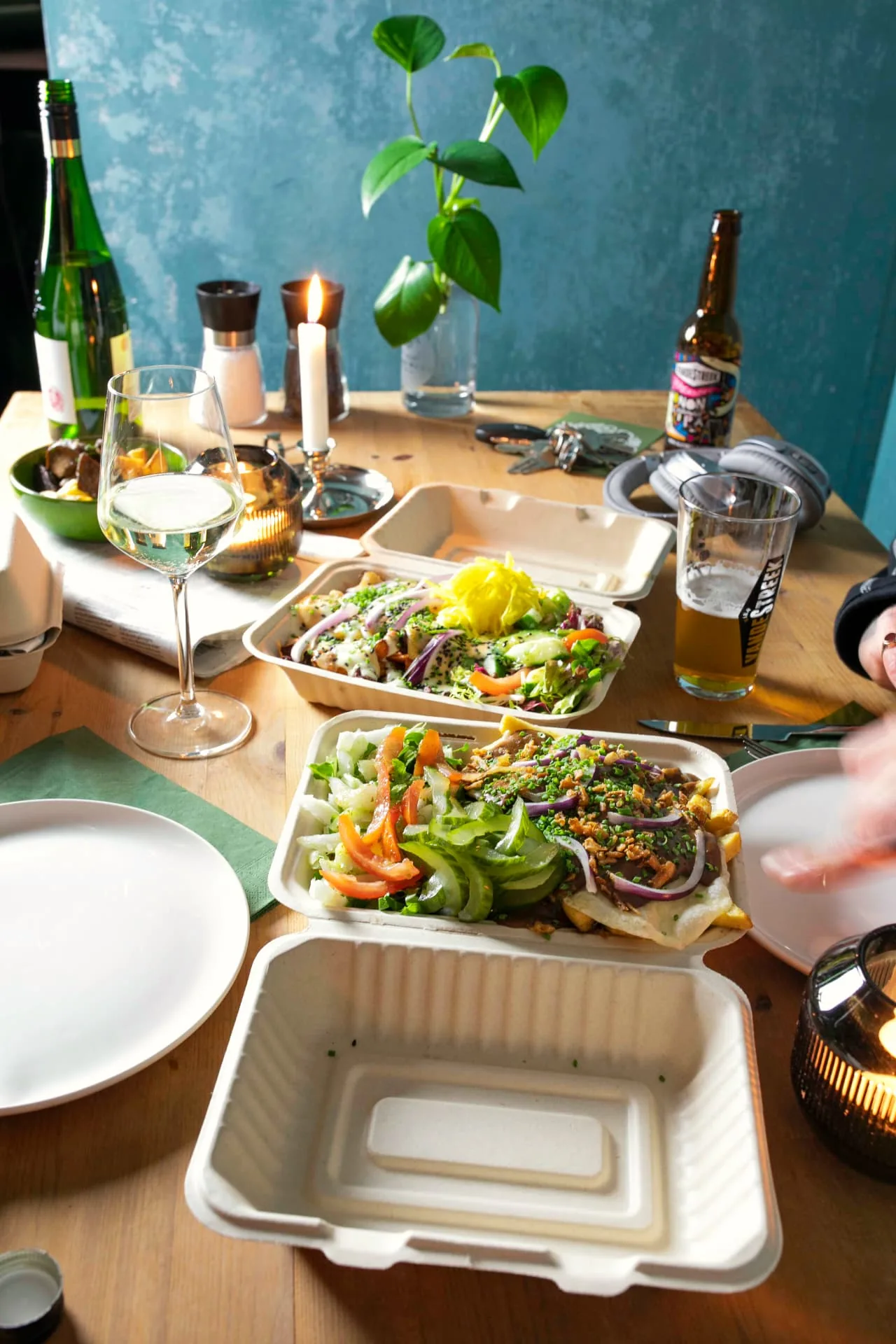 Meerdere bakjes plantaardige kapsalon op een houten tafel met drankjes