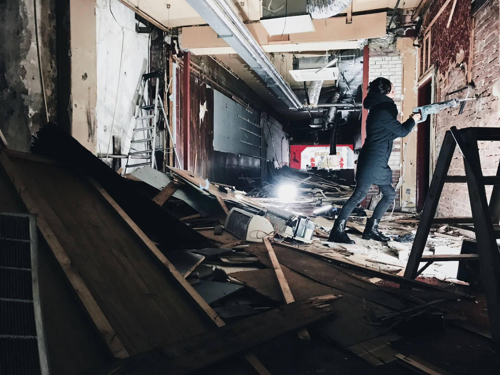 Sloopwerk met een breekhamer aan een binnenmuur tijdens de verbouwing van WAKU WAKU