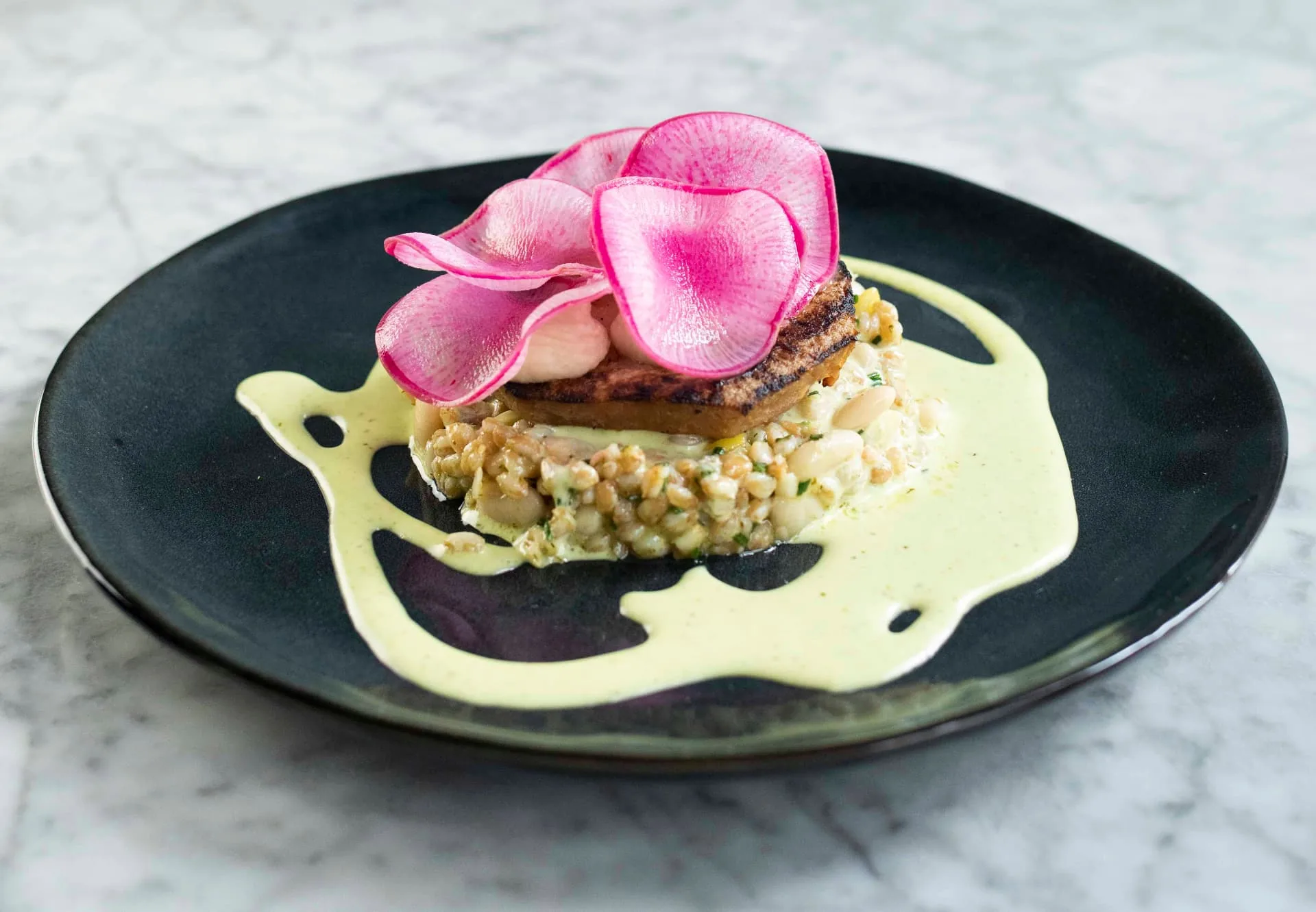 Plantaardig gerecht met gebakken patty, witte bonen en radijs bij WAKU WAKU